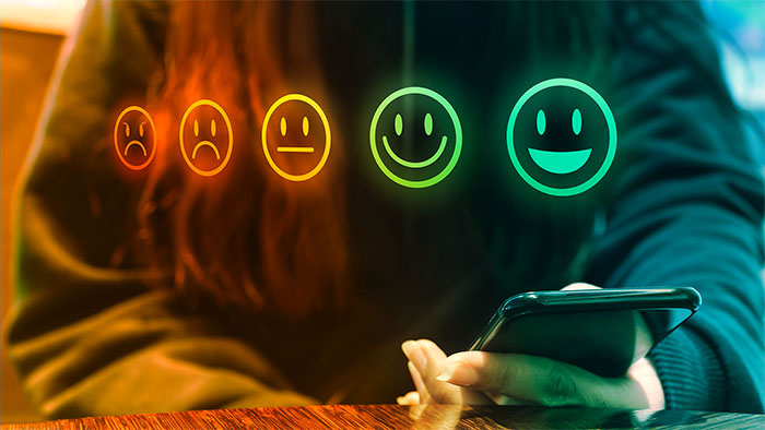 person holding smartphone with satisfaction rating